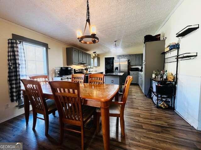 dining room featuring a chandelier, crown molding, dark wood-type flooring, and a textured ceiling