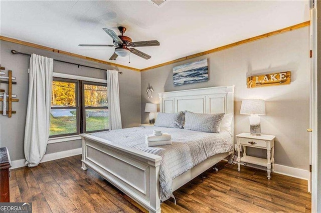 bedroom with ceiling fan, crown molding, and dark wood-type flooring