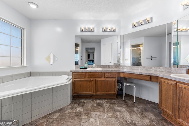 bathroom featuring vanity, a textured ceiling, and independent shower and bath