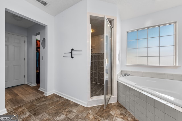 bathroom featuring a textured ceiling and plus walk in shower