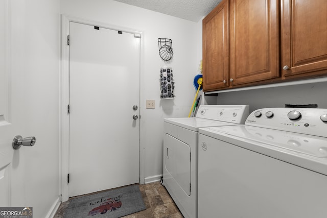 laundry room with cabinets, a textured ceiling, and washing machine and dryer