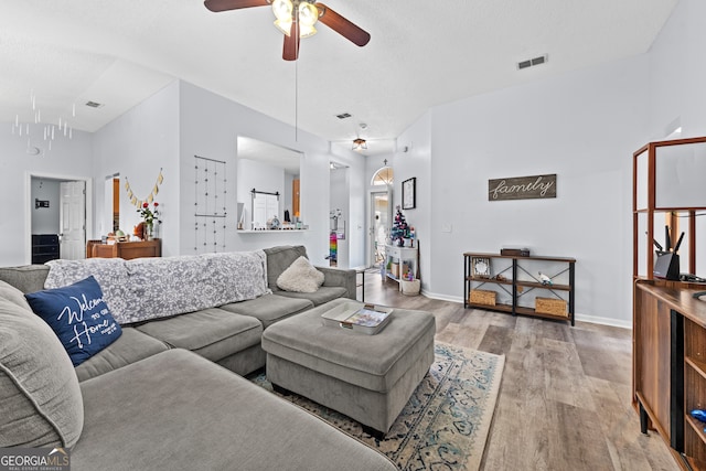 living room featuring ceiling fan and light hardwood / wood-style flooring