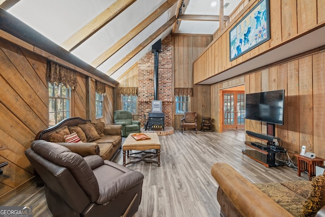 living room with a wood stove, beamed ceiling, high vaulted ceiling, light hardwood / wood-style floors, and wooden walls