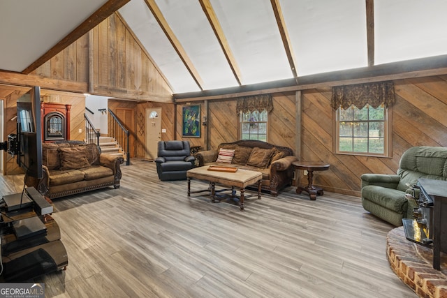 living room featuring wooden walls, light hardwood / wood-style flooring, and lofted ceiling with beams