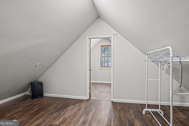 additional living space with dark hardwood / wood-style floors and lofted ceiling