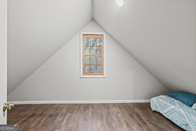 bonus room with lofted ceiling and dark wood-type flooring