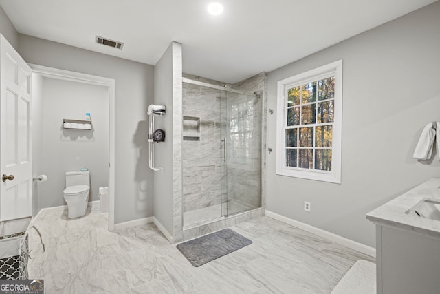 bathroom featuring vanity, toilet, and a shower with door