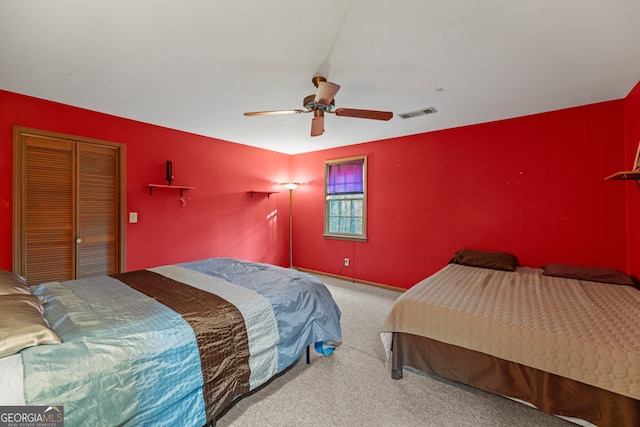 carpeted bedroom with ceiling fan and a closet