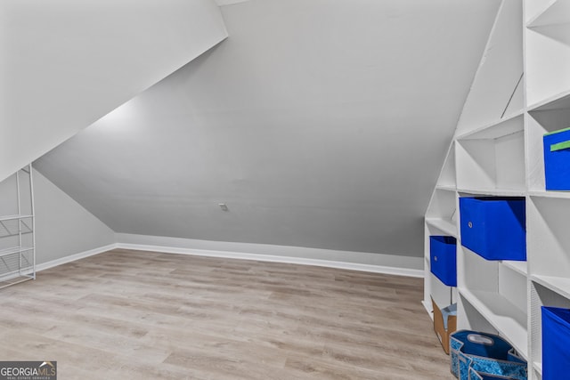 additional living space featuring light hardwood / wood-style flooring and lofted ceiling