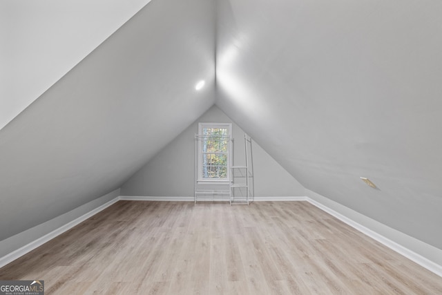 additional living space featuring light hardwood / wood-style floors and lofted ceiling