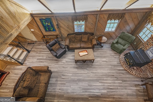 unfurnished living room with wood walls, plenty of natural light, and wood-type flooring