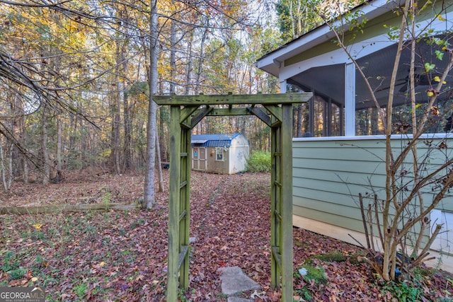 view of yard with a shed and a sunroom