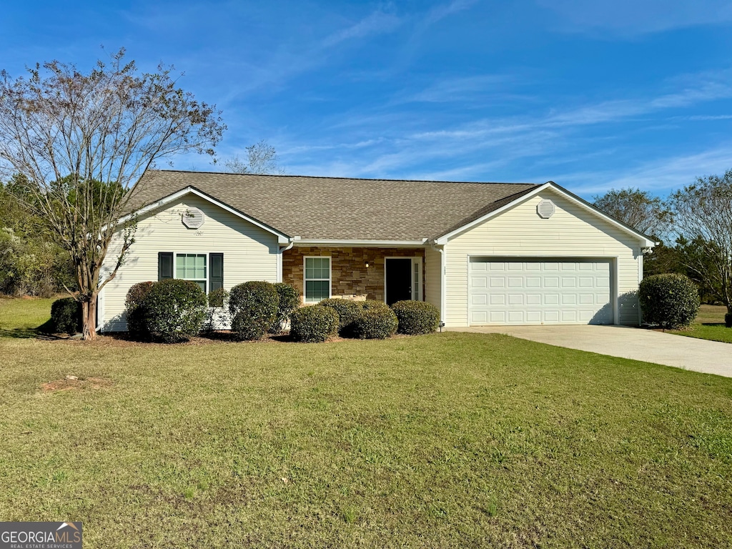 ranch-style house featuring a garage and a front lawn