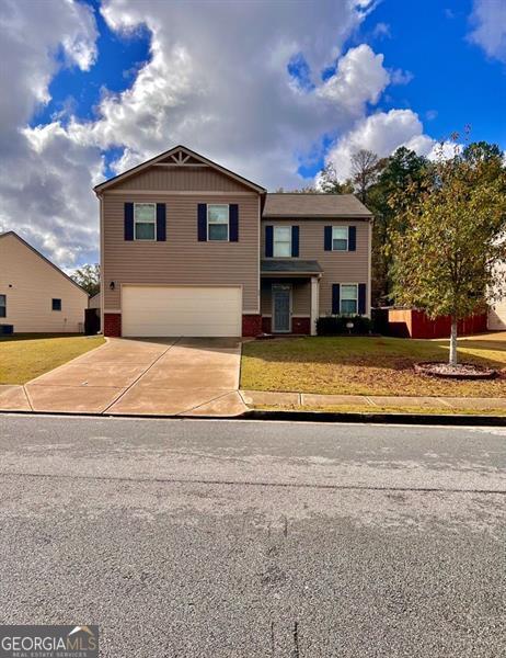 view of front of home featuring a front lawn and a garage