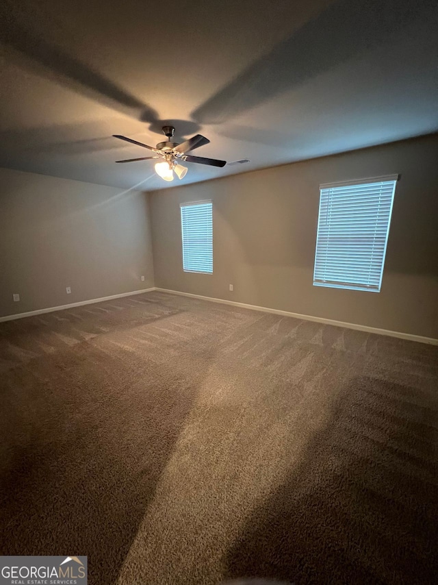 spare room featuring a ceiling fan, visible vents, baseboards, and carpet flooring