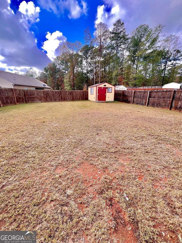 view of yard featuring a storage unit, an outdoor structure, and a fenced backyard