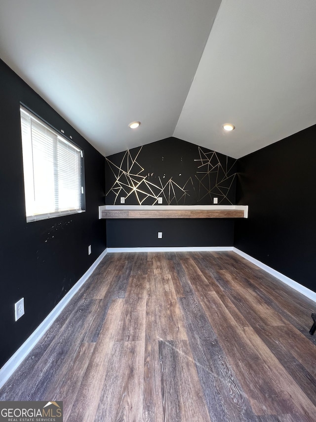 empty room featuring vaulted ceiling, recessed lighting, wood finished floors, and baseboards