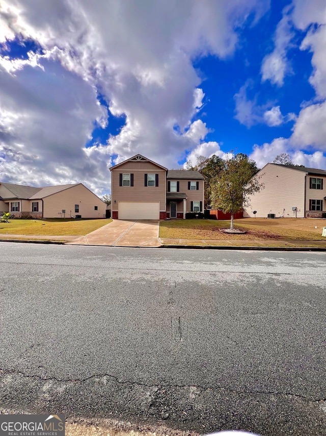 view of front facade with an attached garage, concrete driveway, and a front yard