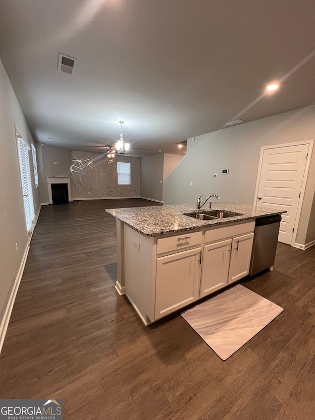 kitchen featuring dark wood finished floors, open floor plan, white cabinets, a sink, and an island with sink