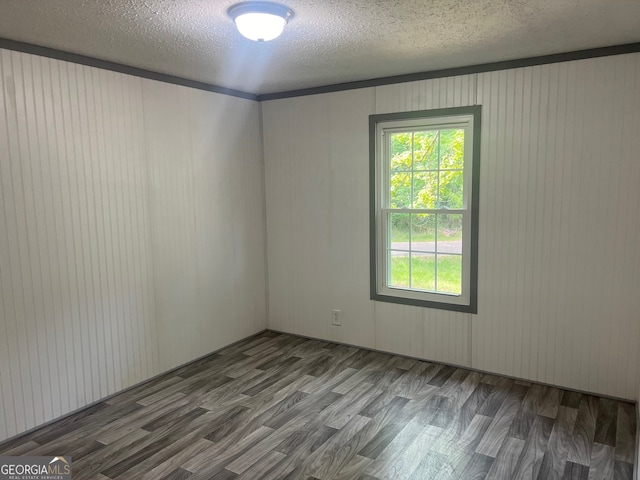 spare room featuring hardwood / wood-style floors and a textured ceiling