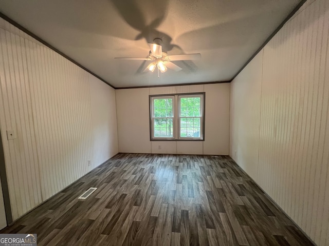 unfurnished room featuring ceiling fan, dark hardwood / wood-style flooring, ornamental molding, and a textured ceiling