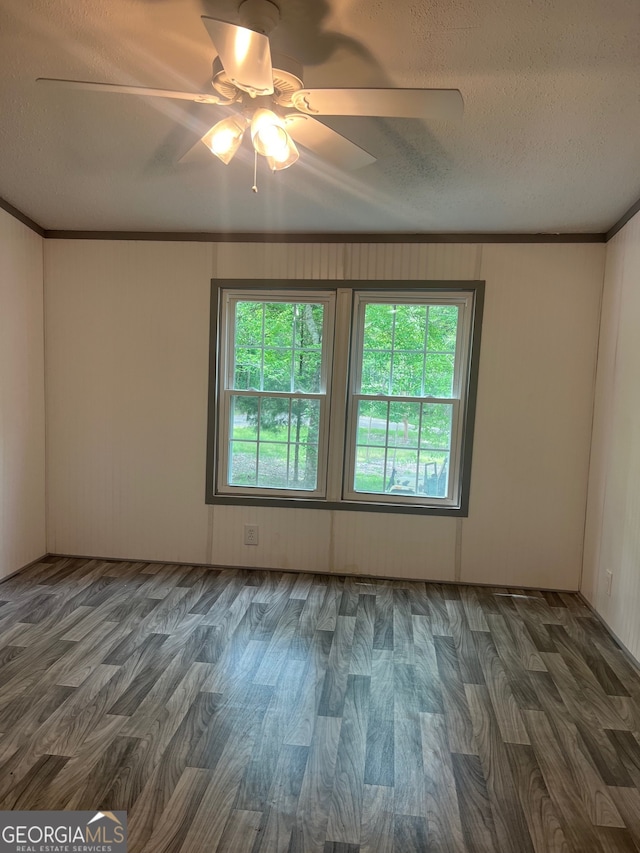 spare room with ornamental molding, a textured ceiling, ceiling fan, and dark wood-type flooring