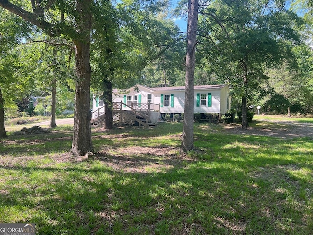 manufactured / mobile home with a front lawn and a wooden deck