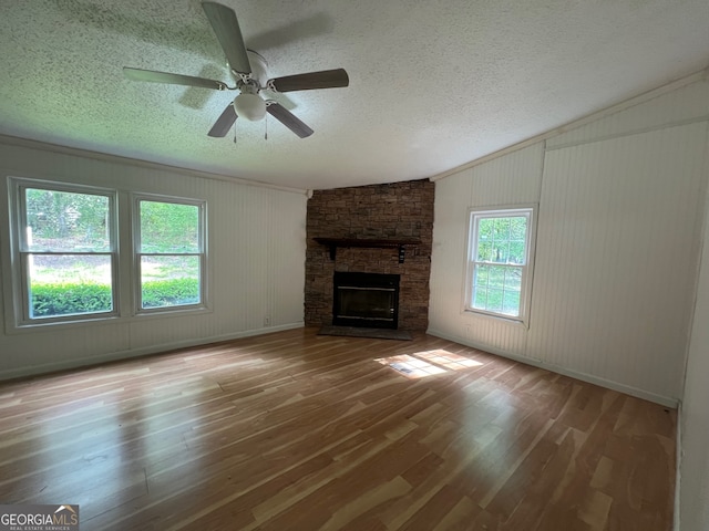 unfurnished living room with a fireplace, wood-type flooring, and a textured ceiling