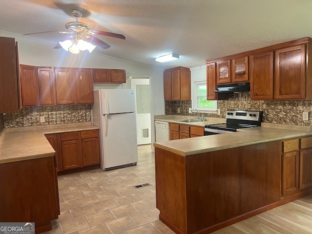 kitchen featuring white appliances, exhaust hood, sink, vaulted ceiling, and kitchen peninsula