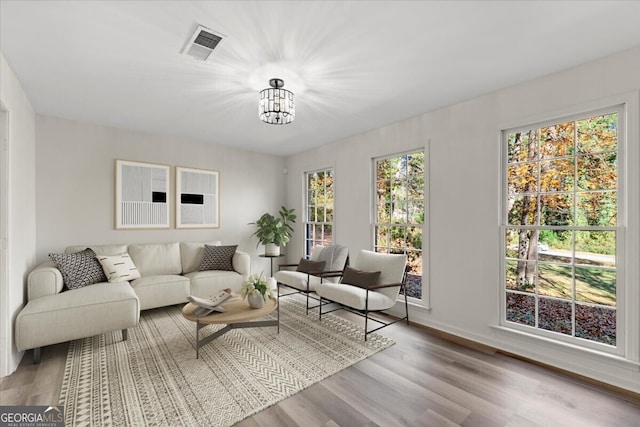 living room with a notable chandelier and light wood-type flooring