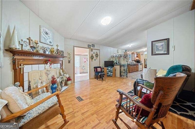 sitting room with hardwood / wood-style flooring and lofted ceiling