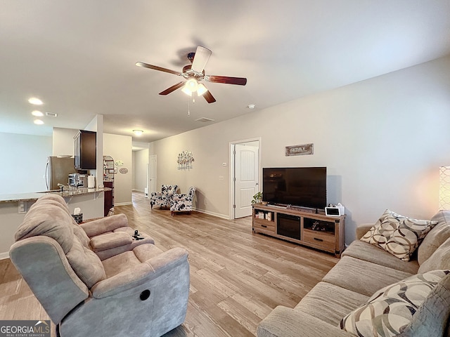 living room with ceiling fan and light hardwood / wood-style floors