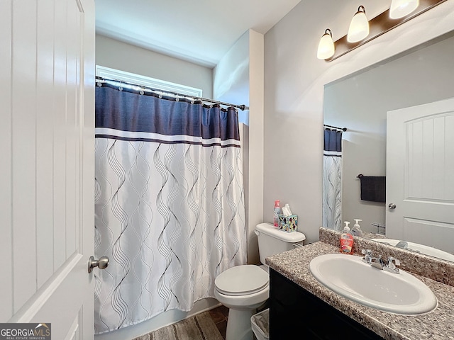 bathroom featuring walk in shower, hardwood / wood-style floors, vanity, and toilet