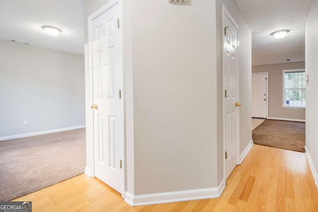 corridor featuring hardwood / wood-style flooring and a textured ceiling