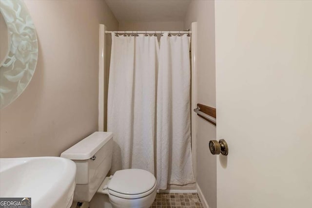 bathroom with walk in shower, tile patterned flooring, and toilet