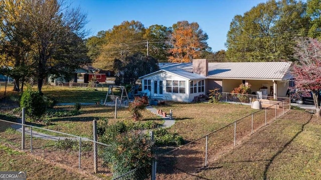 rear view of house with a sunroom and a yard