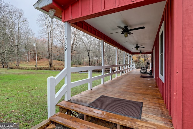 wooden deck featuring ceiling fan and a lawn