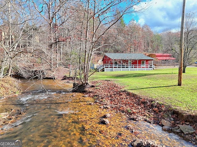 exterior space featuring a forest view and a front lawn