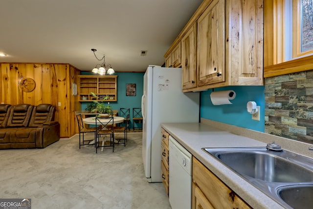 kitchen featuring decorative backsplash, white dishwasher, sink, pendant lighting, and a notable chandelier