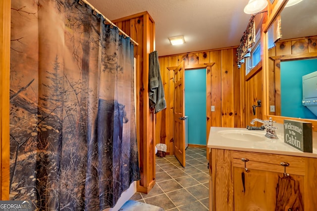 bathroom featuring tile patterned flooring, vanity, and wood walls