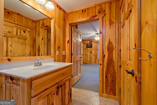 bathroom featuring wooden walls, tile patterned flooring, and vanity