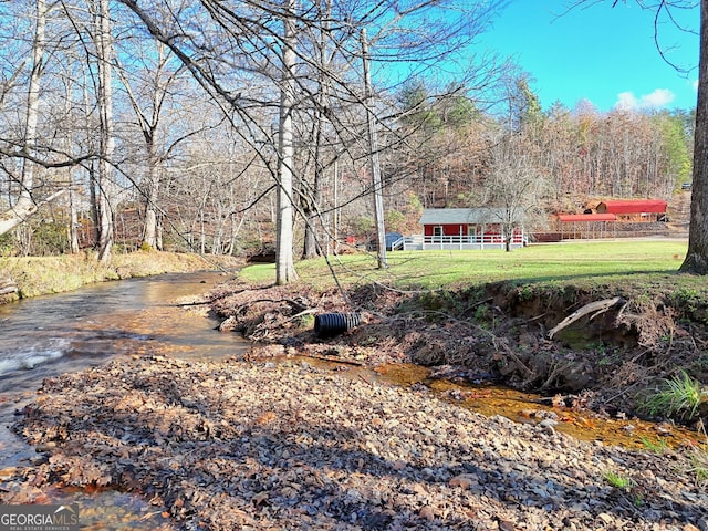 view of yard featuring a water view and a wooded view