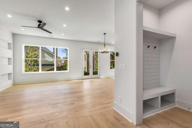 mudroom with ceiling fan with notable chandelier and light hardwood / wood-style floors