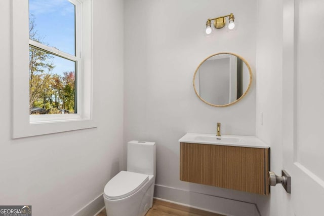 bathroom with hardwood / wood-style floors, vanity, and toilet