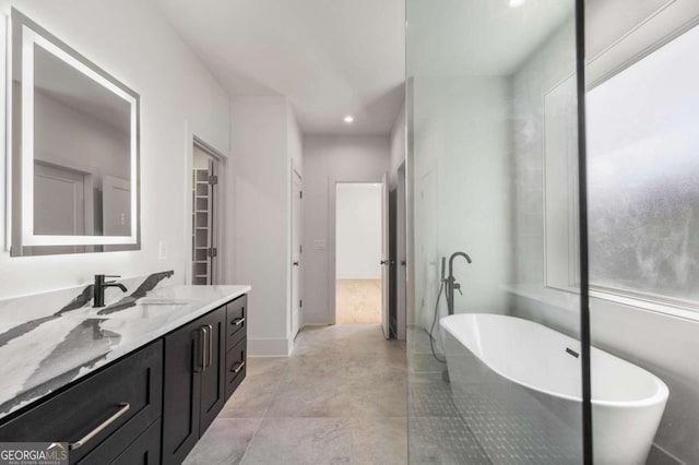 bathroom featuring tile patterned flooring, a washtub, and vanity