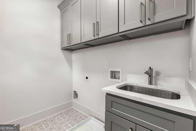 laundry room featuring cabinets, hookup for a washing machine, electric dryer hookup, sink, and light tile patterned floors