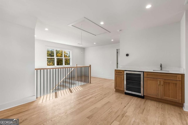 bar with light hardwood / wood-style flooring, wine cooler, and sink