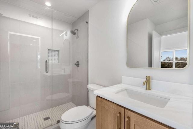 bathroom featuring vanity, toilet, and a shower with shower door