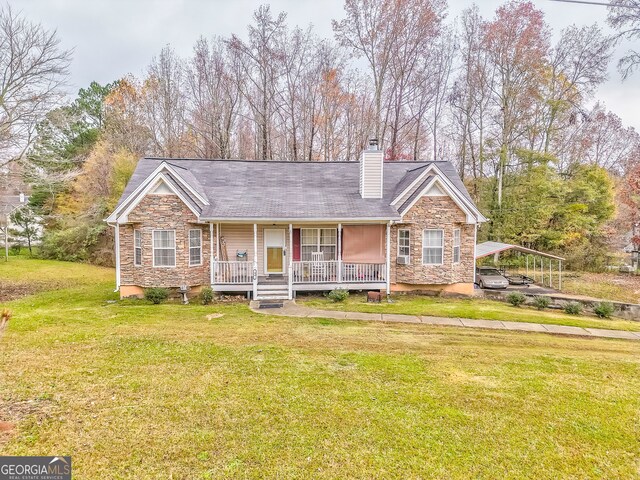 ranch-style home featuring a front lawn, covered porch, and a carport