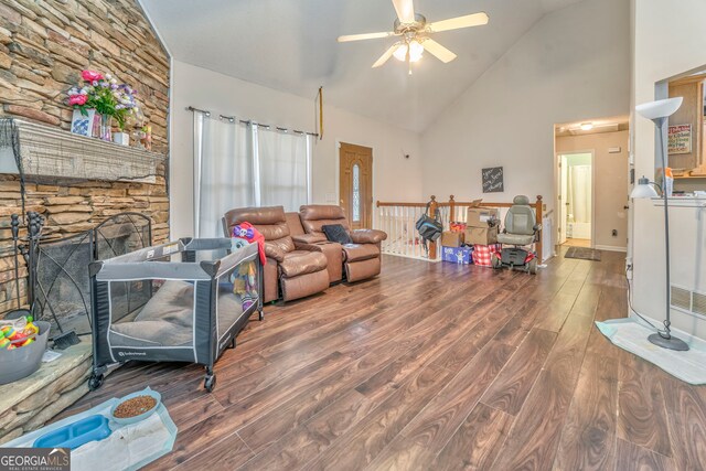 living room featuring hardwood / wood-style floors, ceiling fan, a fireplace, and high vaulted ceiling